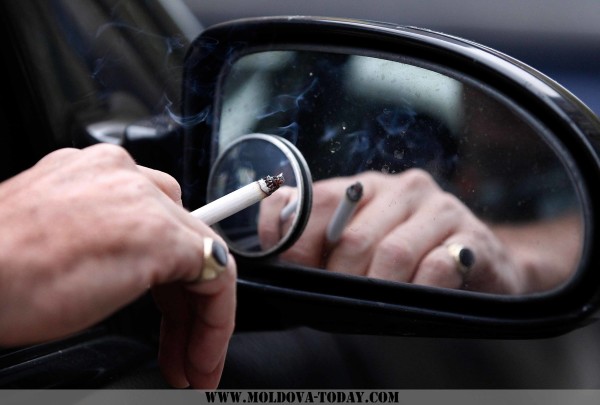 A man smokes a cigarette as he sits in his car in Liverpool