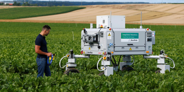 A Bosch employee controls a deep field robot called "BoniRob" at field in Renningen