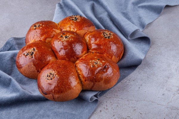 sweet_bun_with_sesame_seeds_placed_on_a_stone_background
