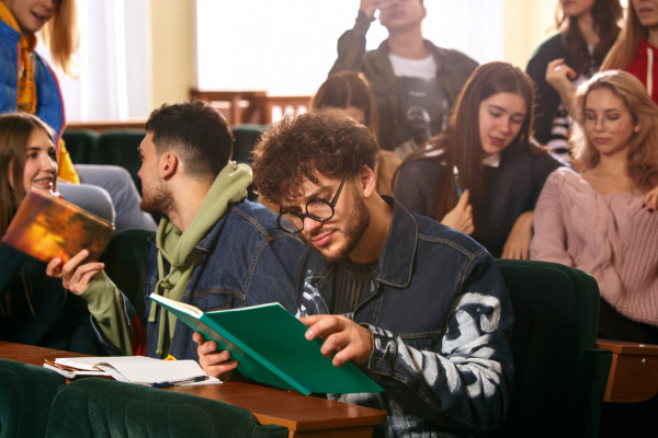 the-group-of-cheerful-happy-students-sitting-in-a-lecture-hall-before-lesson_155003-12217